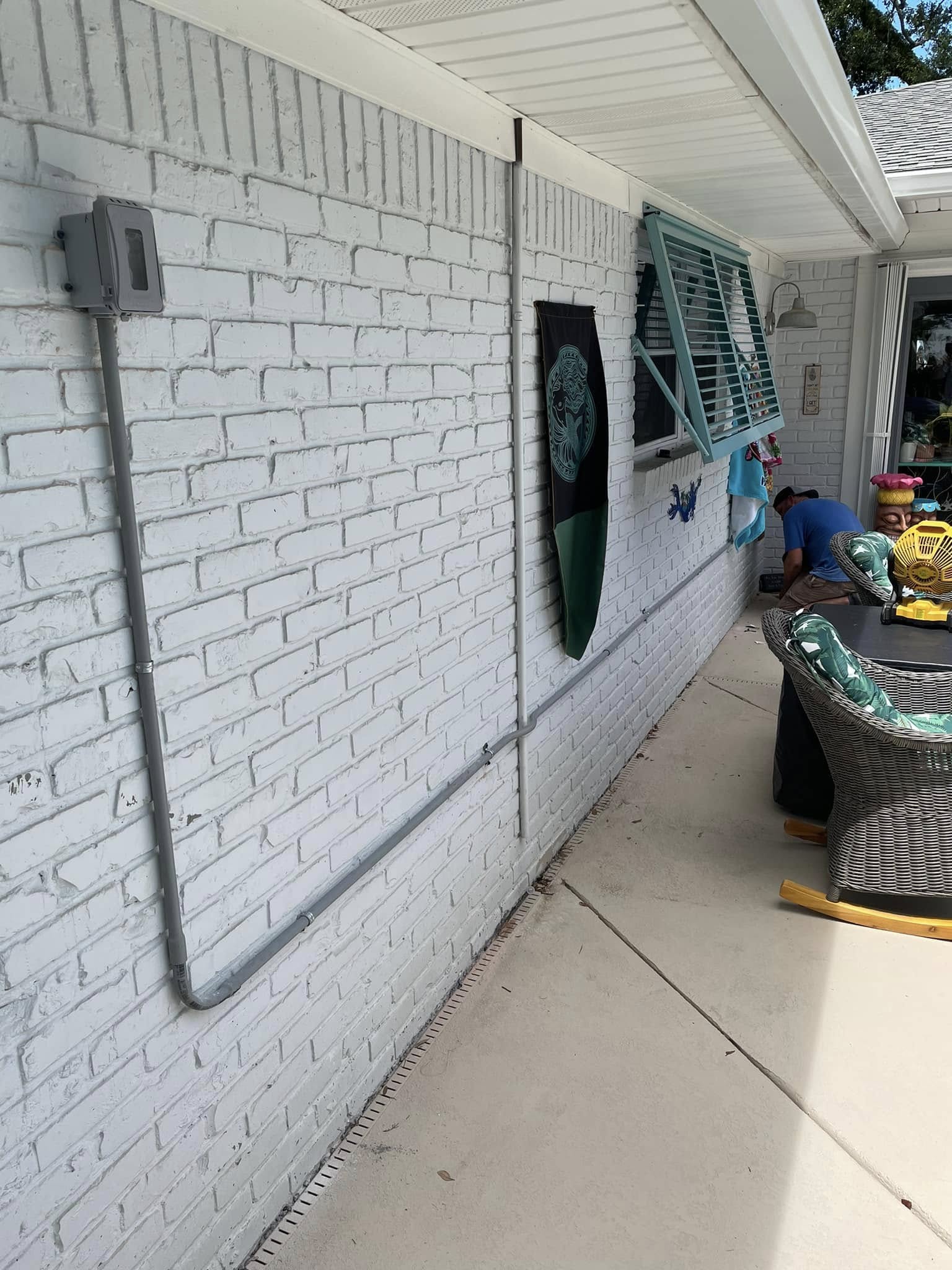 Conduit run along patio wall
