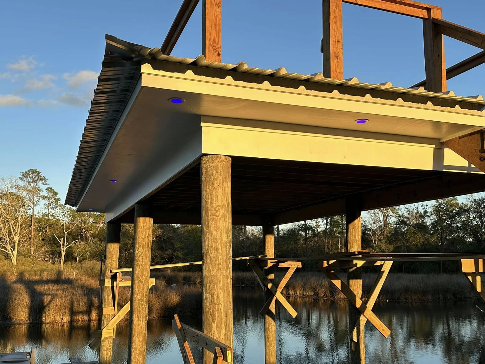 Dock soffit lighting glowing over the water at sunset in Biloxi